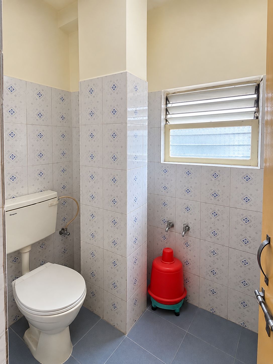 Ein kleines Badezimmer mit Toilette, Dusche und Fenster.