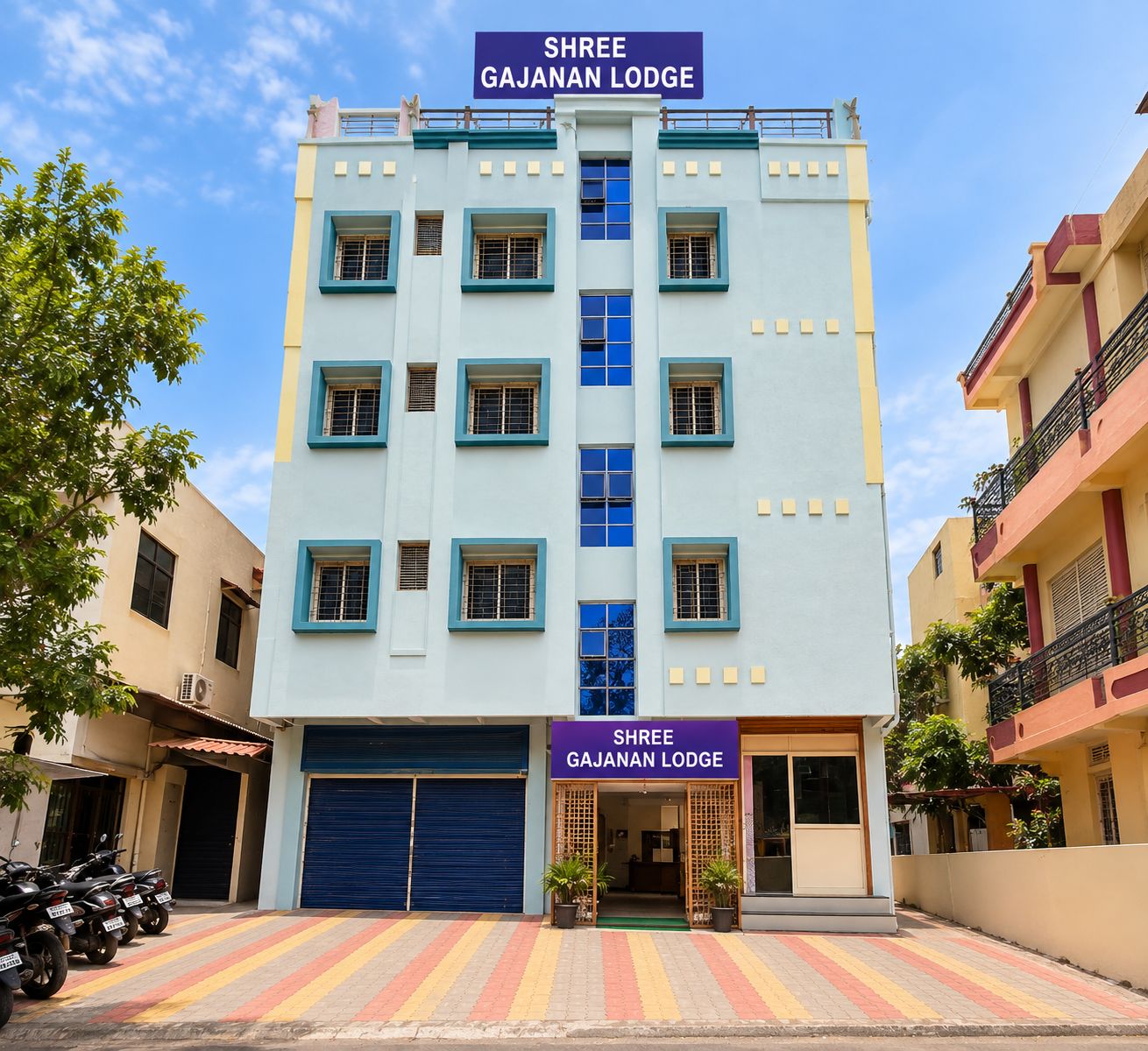Un edificio de varios pisos con un letrero que dice 'Shree Gajanan Lodge'.