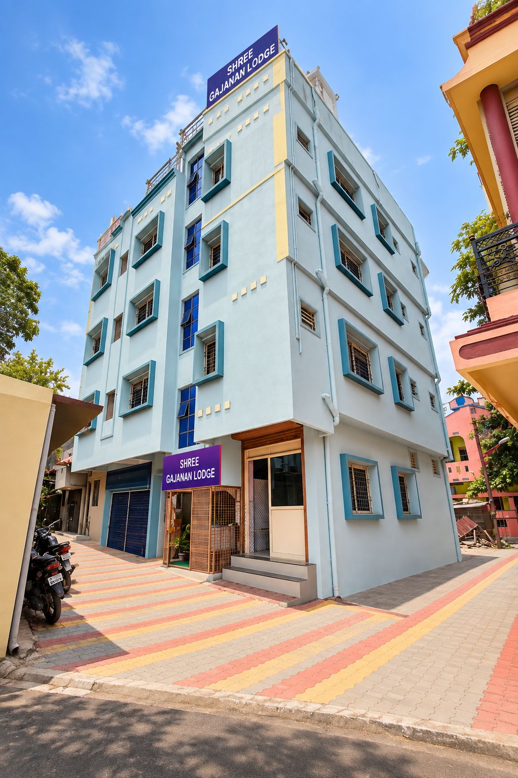 A multi-story building with a sign reading 'Shree Gajanan Lodge.'