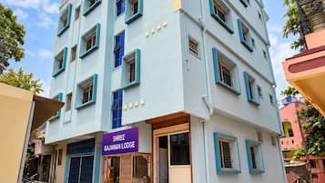 A multi-story building with a sign reading 'Shree Gajanan Lodge.'