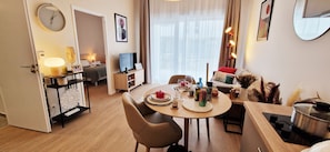 Une chambre d’hôtel moderne équipée d’un coin repas, d’une télévision et d’un lit.