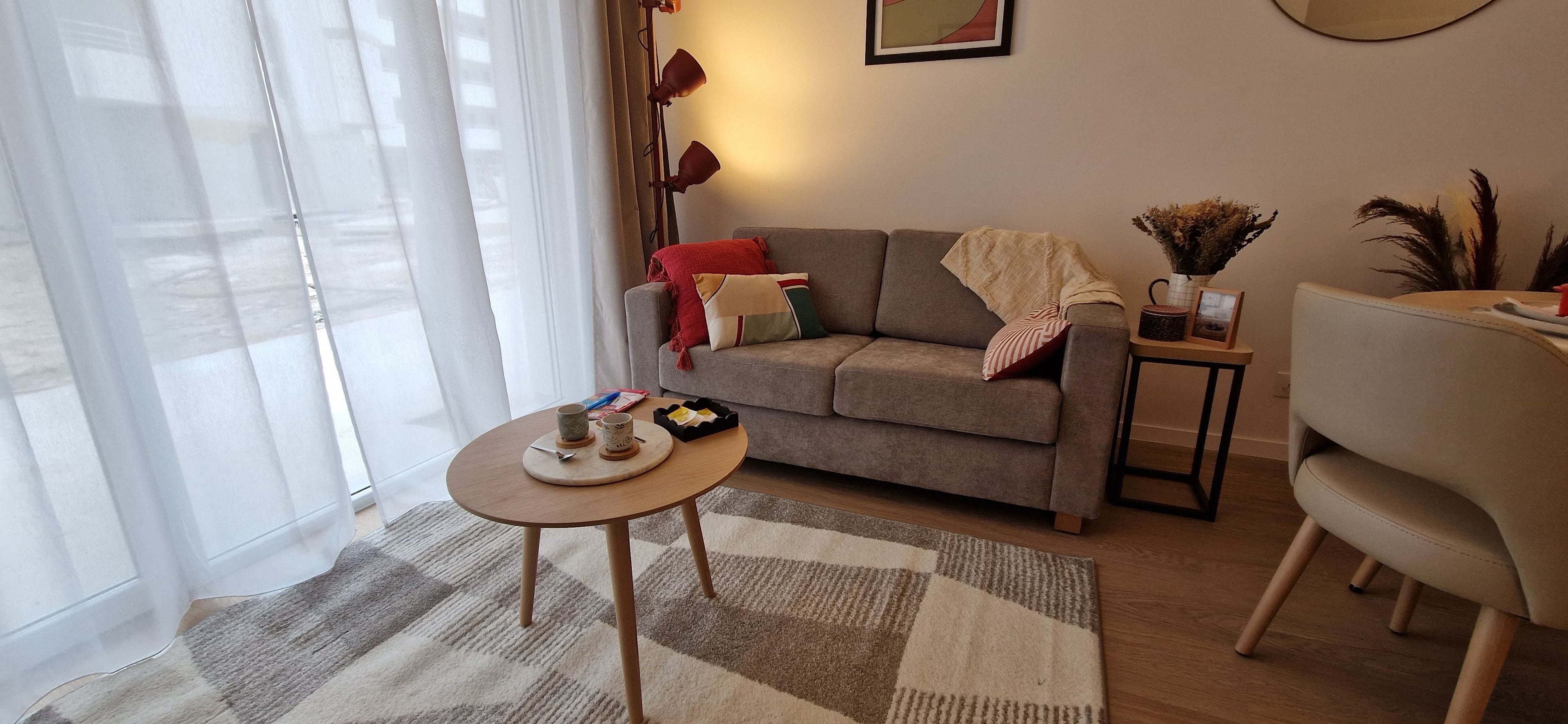 A living room with a sofa, a coffee table, a side table, and a chair.