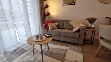 A living room with a sofa, a coffee table, a side table, and a chair.