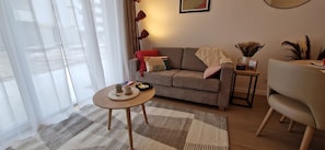A living room with a sofa, a coffee table, a side table, and a chair.