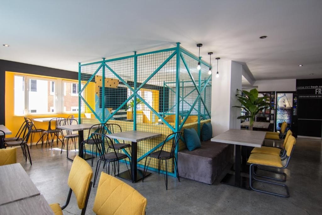 Un interior moderno con comedor, áreas de descanso y una escalera visible.