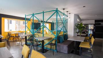 Un interior moderno con comedor, áreas de descanso y una escalera visible.
