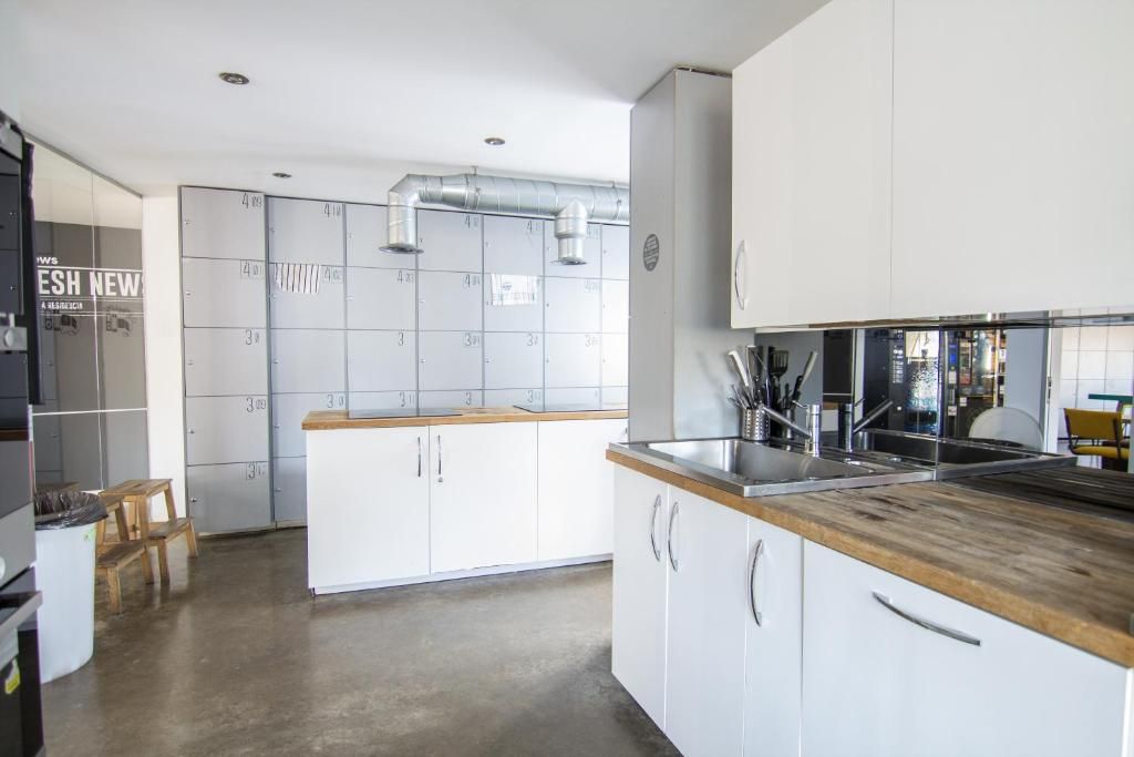 A modern kitchen with white cabinets, a wooden countertop, and stainless steel appliances.