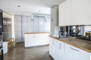 Una cucina moderna con mobili bianchi, un piano di lavoro in legno ed elettrodomestici in acciaio inossidabile.
