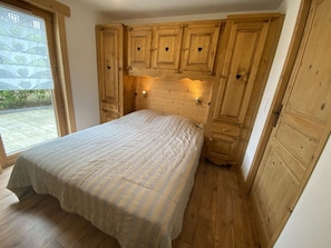 A bedroom with a bed, wooden cabinets, and a window. - Charming apartment, exceptional location - 6 guests (Arêches-Beaufort)