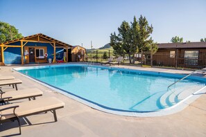 A swimming pool with lounge chairs and a wooden structure. - Cozy Black Hills Rustic Cabin Queen & Twin Trundle Heat AC WiFi Bathhouse Nearby (Piedmont)
