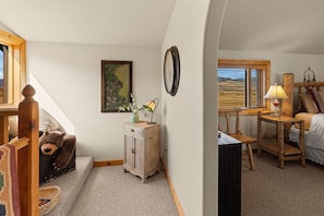 A cozy room with a wooden bed, a desk with a lamp, a clock, and a painting on the wall. - Comfortable, eclectic Montana cabin close to Yellowstone & hot springs (Pray)