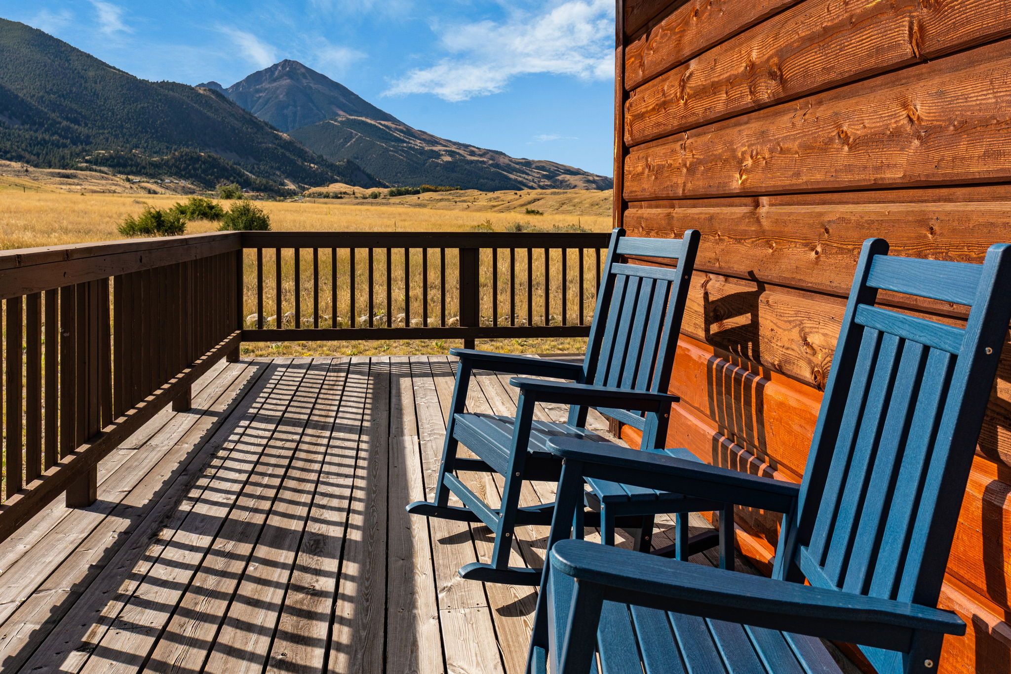 Une terrasse en bois offrant une vue sur une chaîne de montagnes.