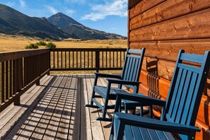 A wooden deck with a view of a mountain range.