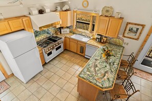 Une cuisine équipée d’une cuisinière, d’un évier et d’un réfrigérateur.