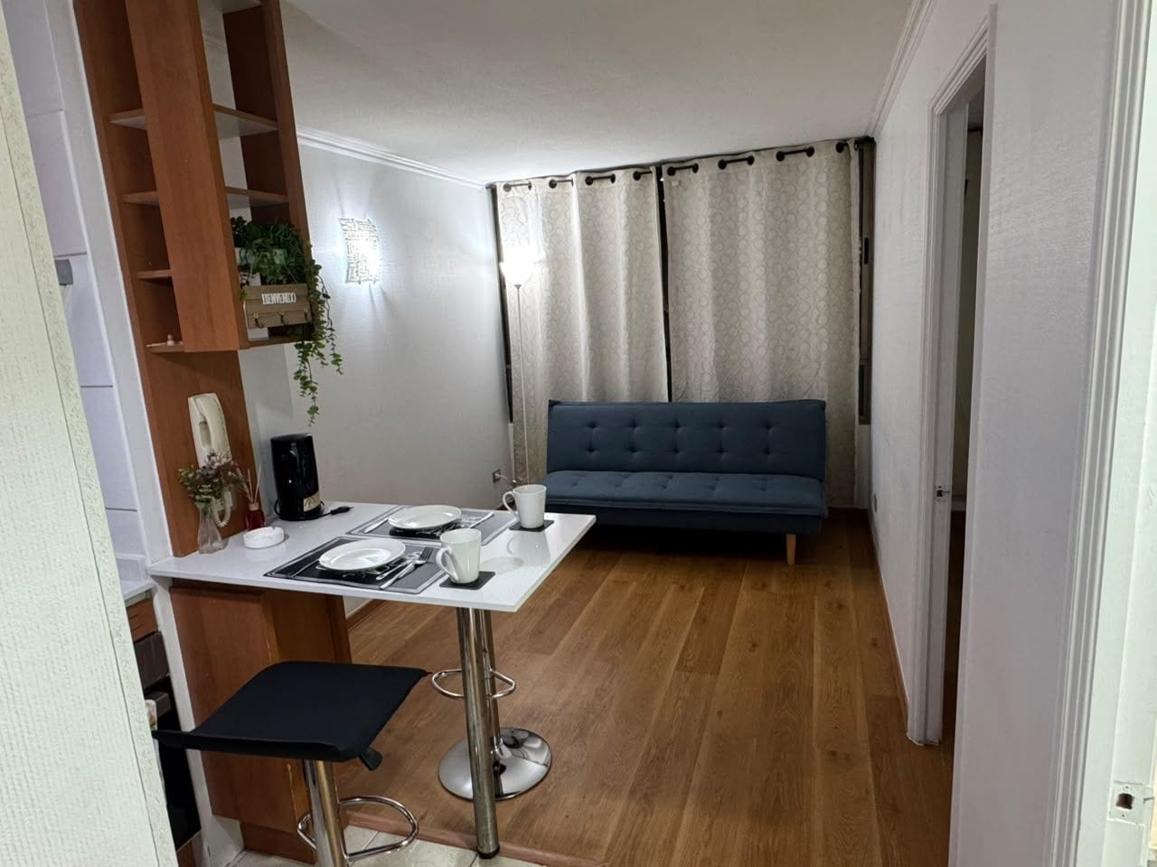 Un espacio habitable compacto con comedor, un sofá y una pequeña mesa con una silla.