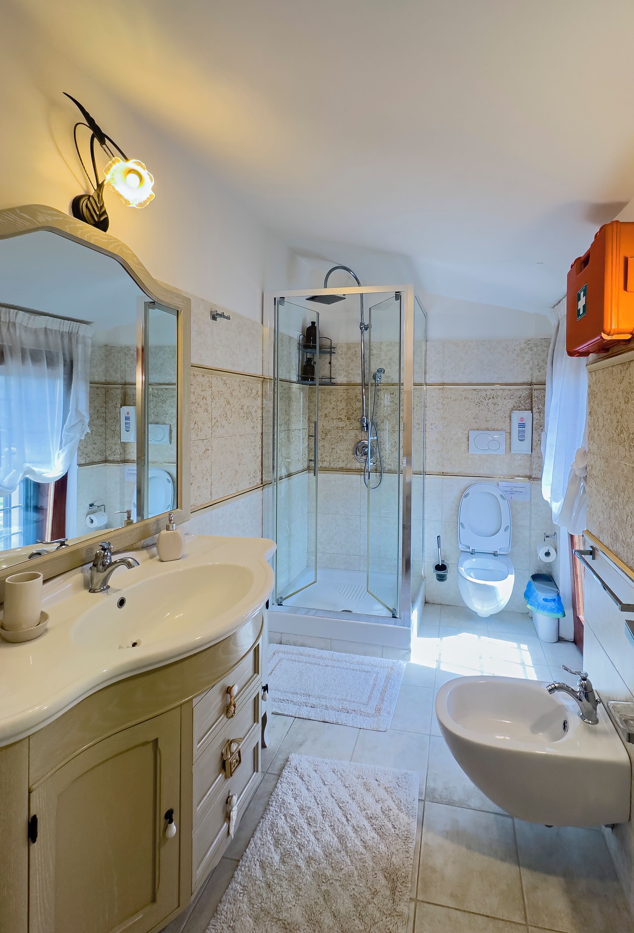 Ein Badezimmer mit einer Duschkabine, einem Doppelwaschbecken und einer Toilette.