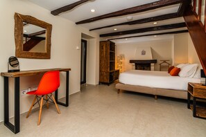 A bedroom with a bed, a desk with a chair, a mirror, and a fireplace. - Holiday Home 'Edele's House' with Mountain View, Private Terrace and Wi-Fi (Tabua)