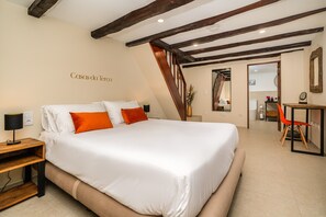 Ein Hotelzimmer mit einem großen Bett, einem Schreibtisch, einem Stuhl und einem Spiegel.