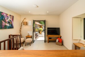 A modern living room with a television, seating area, and a view into a garden. - Holiday Home 'Edele's House' with Mountain View, Private Terrace and Wi-Fi (Tabua)