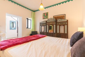 Ein Schlafzimmer mit einem Bett, einem Ventilator, einer Tür und einem Fenster.