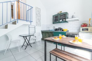 Eine moderne Küche mit Essbereich, einer Treppe und Blick zum Wohnzimmer.