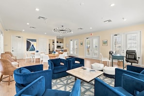 A spacious lounge area with multiple seating options, a central coffee table, and a modern chandelier. - Bayfront Naples – Downtown Waterfront Living with Rooftop Pool & Restaurants (Naples)