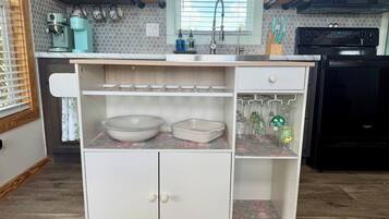 A kitchen with a built-in white cabinet, a coffee maker, and a microwave.