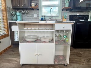 A kitchen with a built-in white cabinet, a coffee maker, and a microwave.