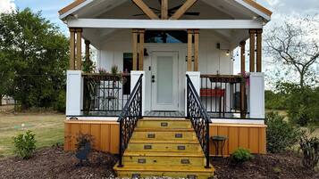 A building with a porch, wooden steps, and a door.