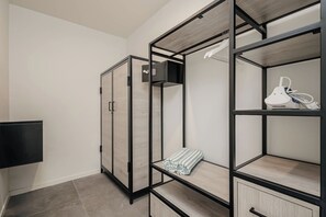 Ein modernes Zimmer mit einem Kleiderschrank, einem Regal mit Handtuch und einem weißen Gerät.