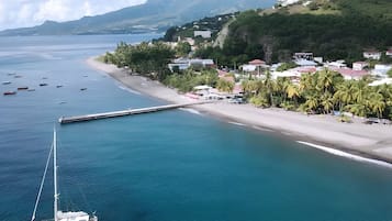 A coastal town with a marina, a beach, and a mountain in the background.