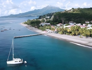 A coastal town with a marina, a beach, and a mountain in the background.