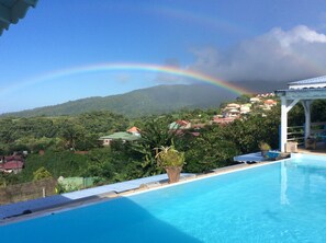 Piscina com vista para uma área residencial e uma cordilheira.