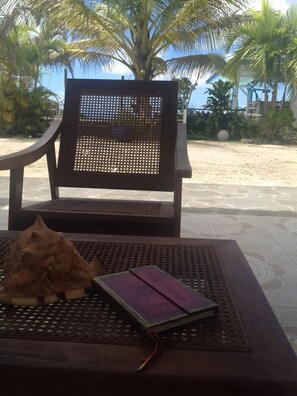 A wooden chair with a mesh backrest, a wooden table with a decorative pattern, and a book with a red bookmark.