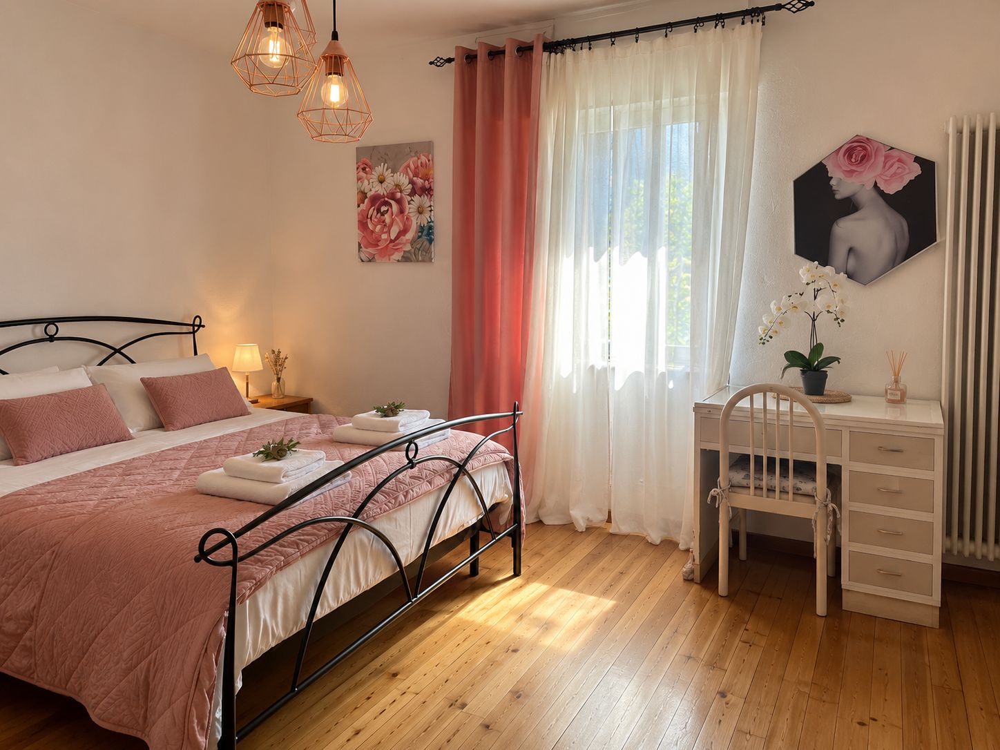 A bedroom with a bed, bedside tables, a desk, and a chair.