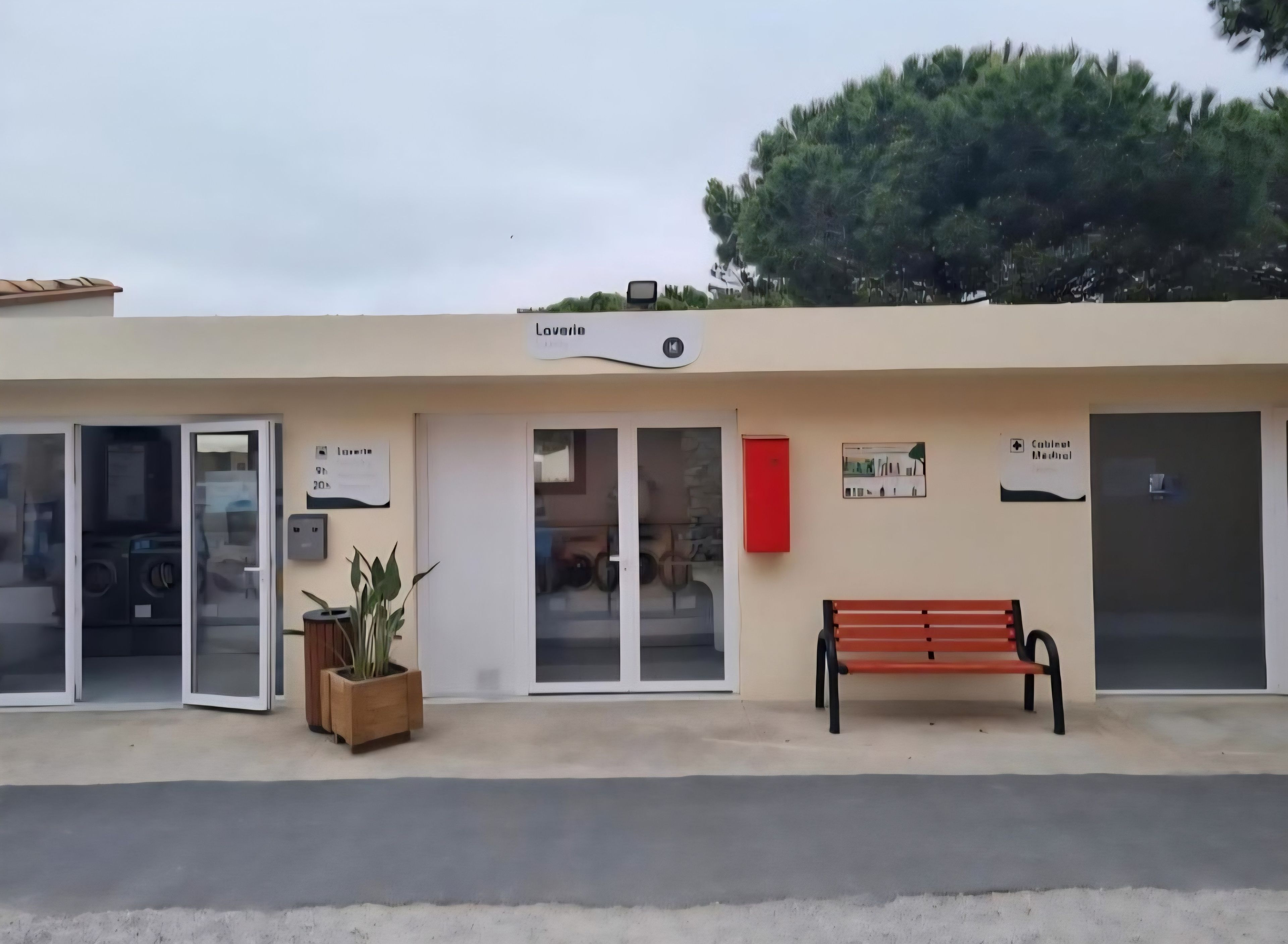 Ein Gebäude mit einem Schild, auf dem 'Laviera' steht, und einer Bank davor.