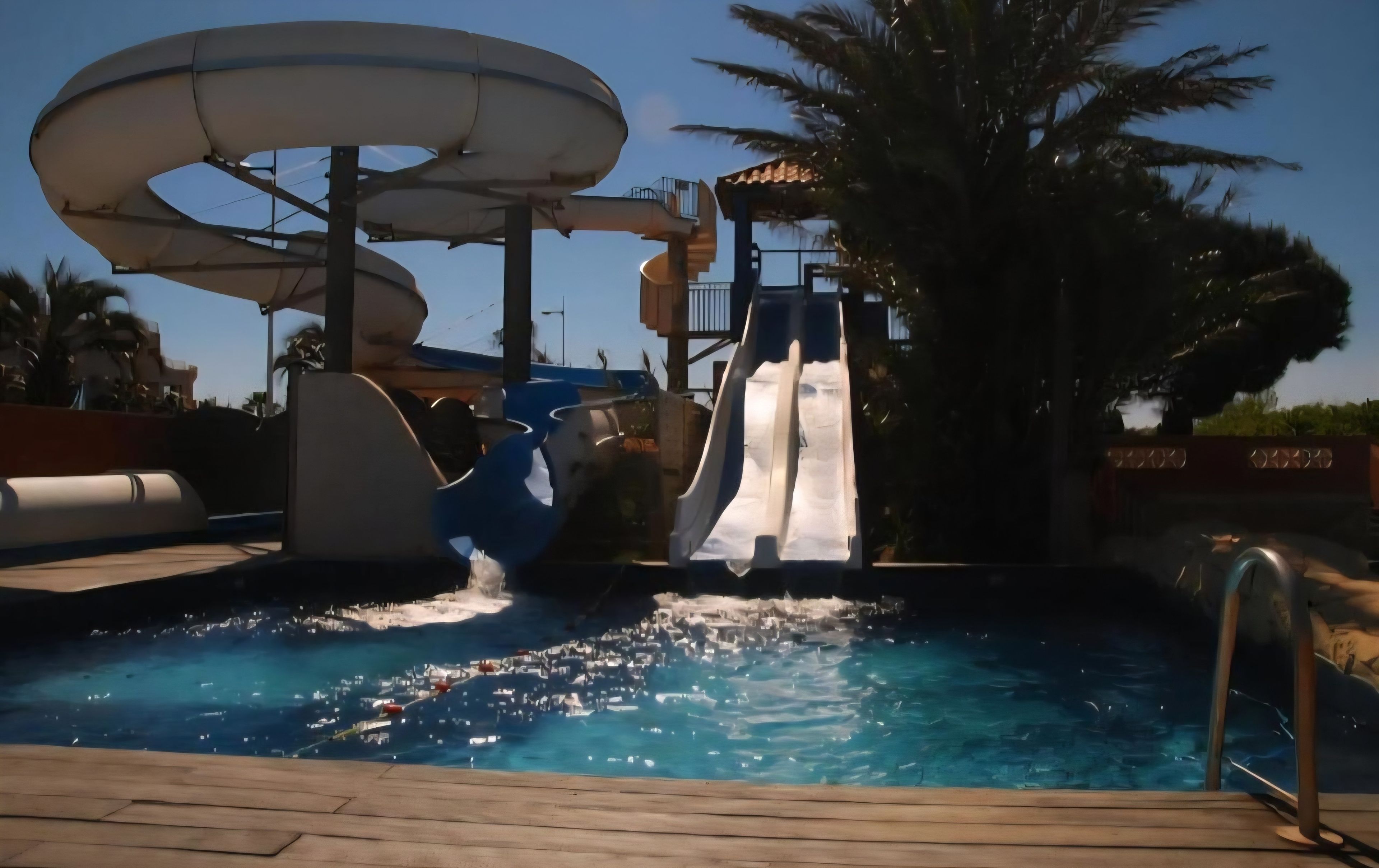 Een waterpark met een grote glijbaan en een zwembad.