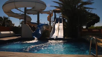 Een waterpark met een grote glijbaan en een zwembad.