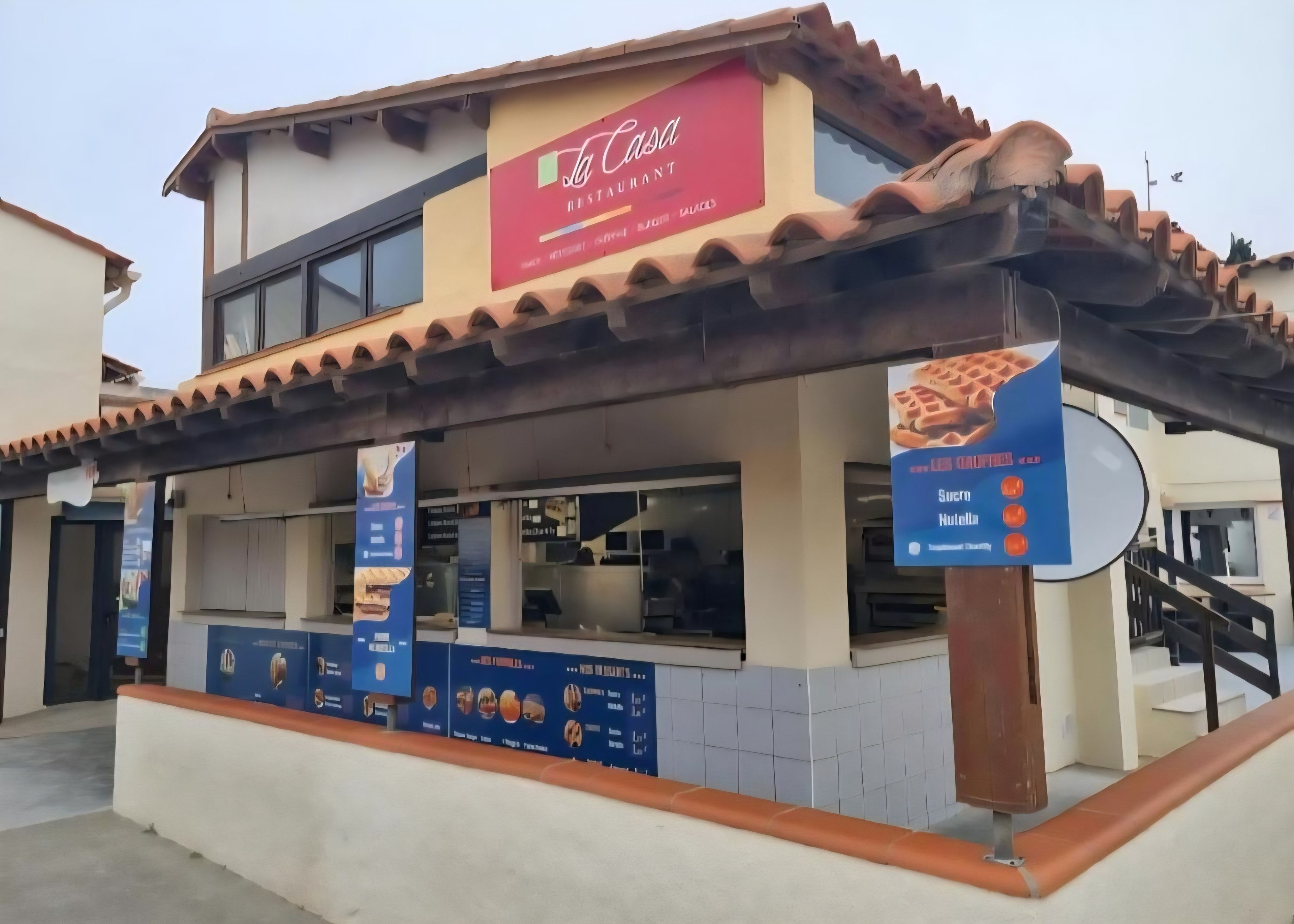 A restaurant with a signboard, a menu board, and a staircase.