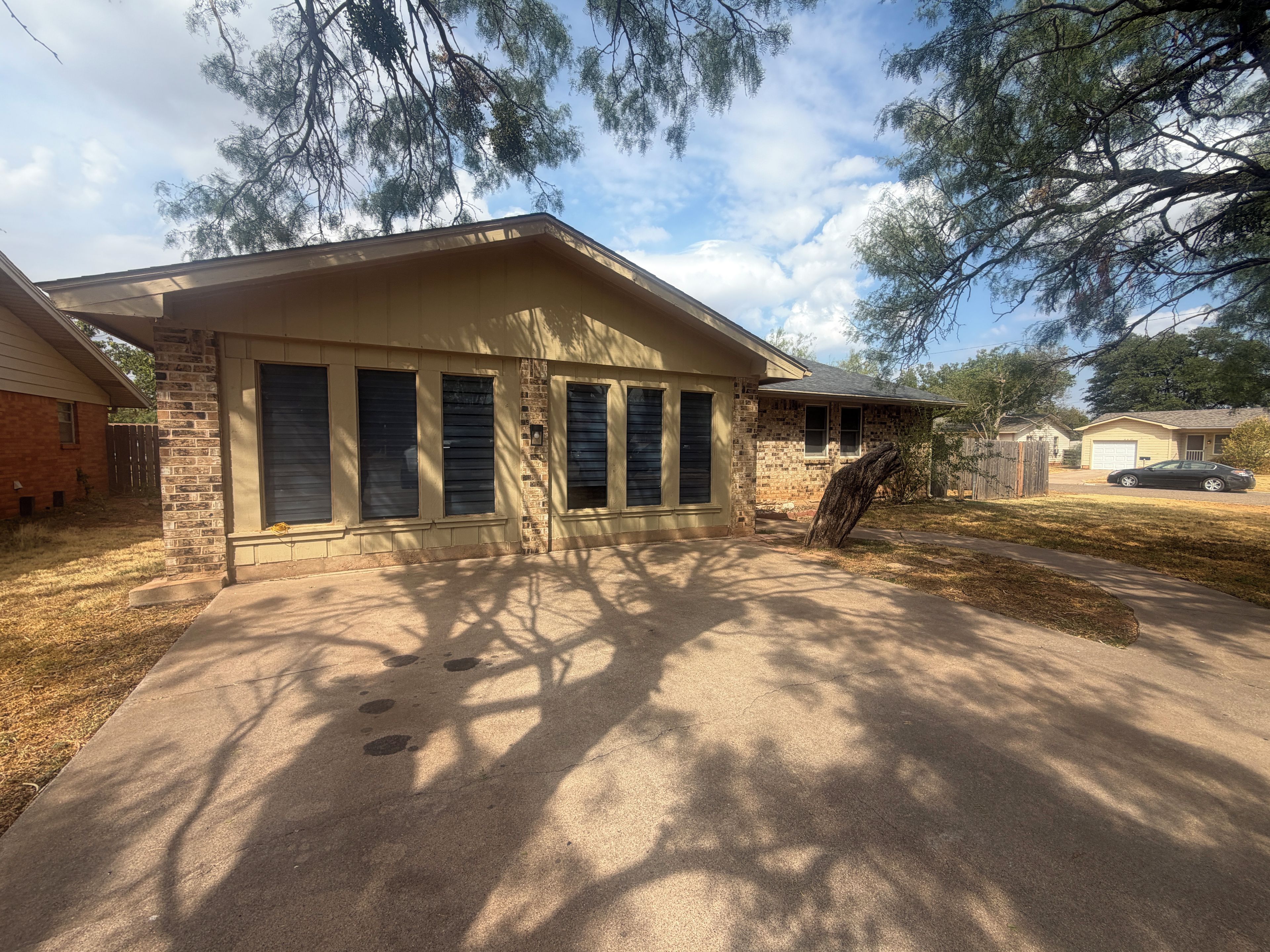 Une maison d’habitation avec un garage, une allée et une pelouse.