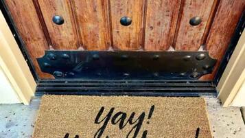 Puerta de madera con felpudo que dice '¡genial, ya llegaste!'