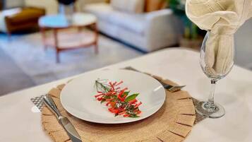 Une table à manger avec une assiette blanche, un verre d’eau et une serviette.