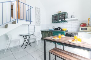 Eine moderne Küche mit Essbereich, einer Treppe und Blick zum Wohnzimmer.