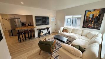 A modern living room with a sofa, a coffee table, and a TV.