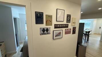 A hallway with a wall decorated with various signs and a framed picture.
