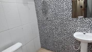 Ein Badezimmer mit Toilette, Waschbecken und einer Wand mit Muster.