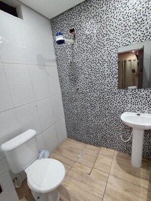 Un bany amb vàter, rentapel i una paret amb un disseny decoratiu.