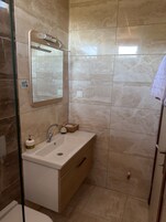 A bathroom with a mirror, sink, and a towel rack.