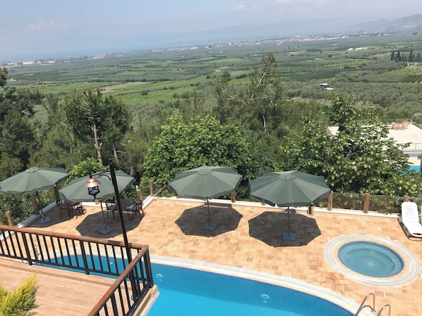 A pool area with a view of a distant town and countryside.