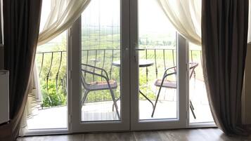 A room with a sliding glass door leading to an outdoor balcony with chairs.
